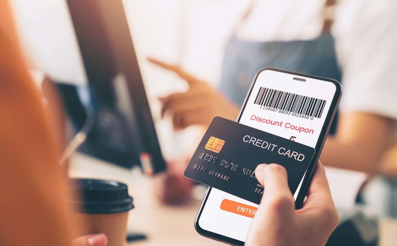 holding credit card and using smartphone with scan barcode for discount code coupon, shopping online